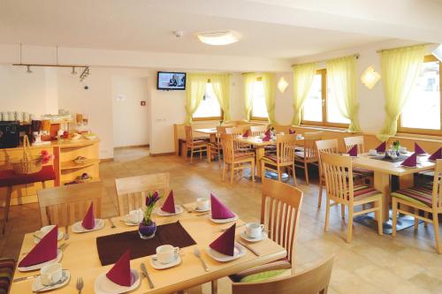 un ristorante con tavoli e sedie con cappelli rossi di Appartementhaus zum Zegger a Neustift im Stubaital