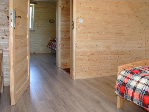a room with wooden walls and a bed in a room at Bieszczadzki Zakątek 787-899-185 in Bukowiec