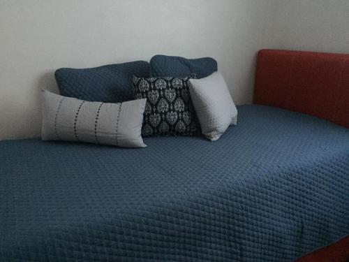 a blue bed with pillows on top of it at Casa Molcajete in Mexico City
