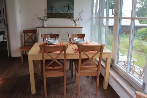 a dining room table and chairs with a table and windows at Rekreační vilka Zlenice in Zlenice 