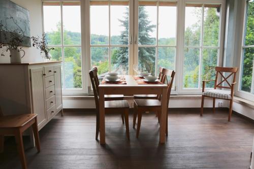 a dining room with a table and chairs and windows at Rekreační vilka Zlenice in Zlenice 