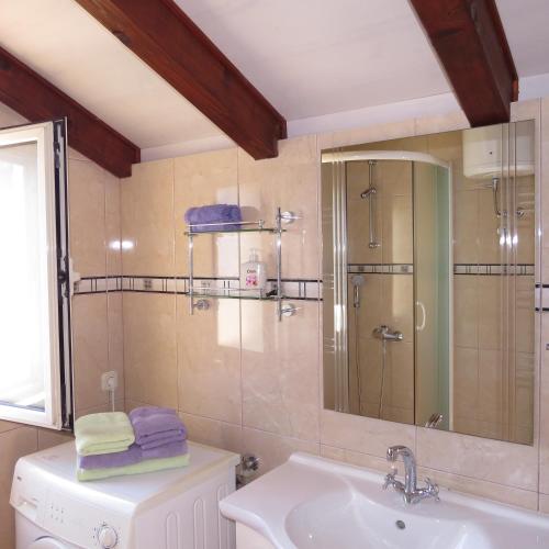 a bathroom with a shower and a sink and a mirror at Apartmani Rita in Milna
