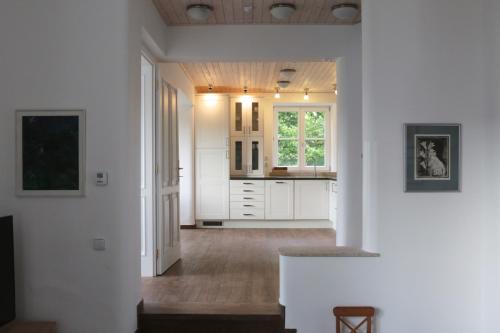uma cozinha com armários brancos e piso em madeira em Rekreační vilka Zlenice em Zlenice 