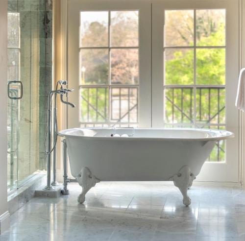 baño con bañera blanca y ventanas en The Oliver, Oxford en Oxford