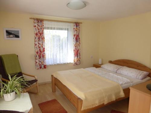 ein Schlafzimmer mit einem Bett, einem Stuhl und einem Fenster in der Unterkunft Ferien-Apartment mit Gartenblick in Rostock