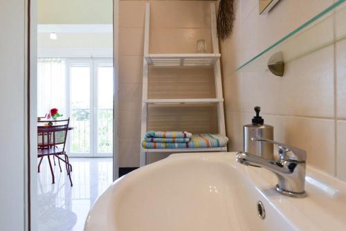 a bathroom with a sink and a view of a table at Apartment Vesna in Zadar