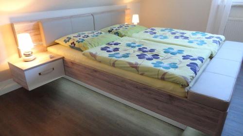 ein Schlafzimmer mit einem Bett und einem Nachttisch mit einem Bett von 6 x 6 cm in der Unterkunft Ferienwohnung Melina in Binz