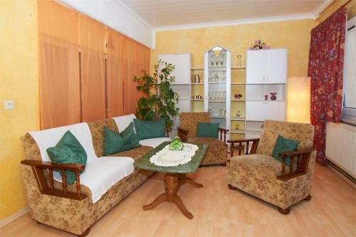 ein Wohnzimmer mit einem Sofa, Stühlen und einem Tisch in der Unterkunft Ferienwohnung für 4 Personen in Sassnitz in Sassnitz