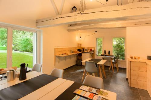 une cuisine et une salle à manger avec tables et chaises dans l'établissement La Pomme Pétillante, à Maisnières