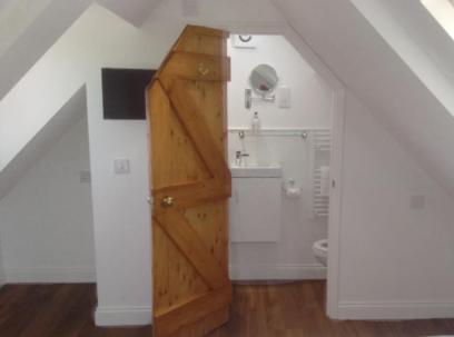 Habitación con baño y armario de madera. en Pump View, en Weymouth
