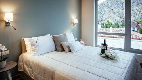 ein Schlafzimmer mit einem großen Bett und einem großen Fenster in der Unterkunft Filoxenion Luxury Rooms & Lofts in Nafplio
