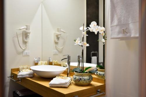 a bathroom with a bowl sink and a mirror at Kete Deluxe Rooms in Marina di Palma