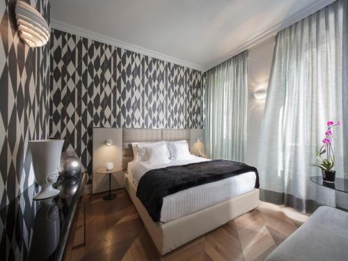 a bedroom with a bed with a black and white patterned wall at Hotel Palazzo Manfredi – Small Luxury Hotels of the World in Rome
