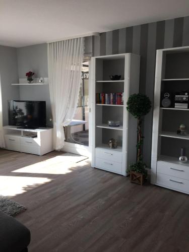 a living room with white shelves and a tv at Andrea-EG in Büsum