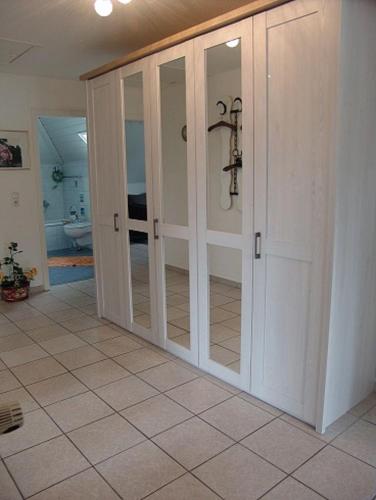 Zimmer mit Glasschiebetüren auf einem Fliesenboden in der Unterkunft Haus Norderpiep in Büsum