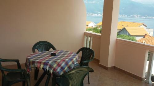 a dining room with a table and chairs and a window at Apartments David&Daniel in Tivat