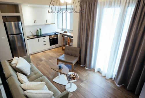 a living room with a couch and a kitchen at Filoxenion Luxury Rooms & Lofts in Nafplio