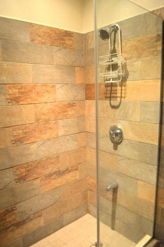 a shower with a wooden wall in a bathroom at Ella's Park View Townhouse Crown Point in Crown Point