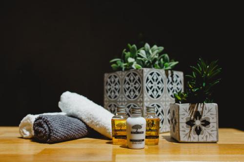 a table with three bottles of essential oils and a plant at Filoxenion Luxury Rooms & Lofts in Nafplio