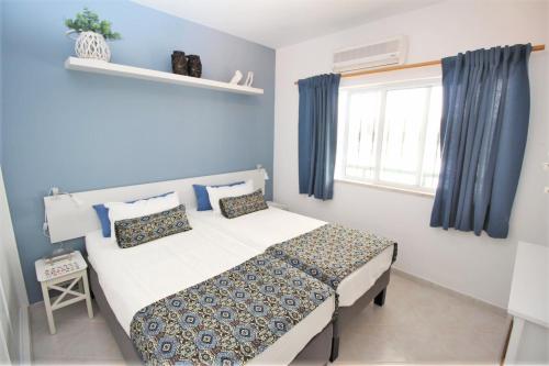 アルマカオ・デ・ペラにあるRecanto 83のベッドルーム1室(青い壁のベッド1台、窓付)