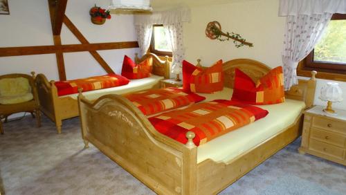 1 dormitorio con 2 camas con almohadas de color rojo y naranja en Ferienwohnung-Wasserlaeufer en Mulde
