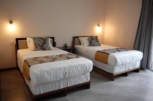 a hotel room with two beds in a room at Luganvilla Business Hotel and Restaurant in Luganville