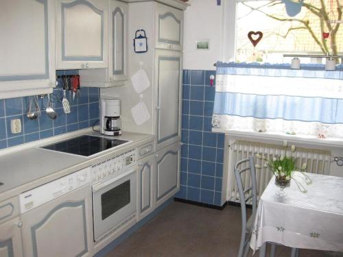 eine Küche mit weißen Schränken und blauen Fliesen in der Unterkunft Gästezimmer in Rotenburg in Rotenburg an der Wümme