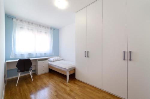 a bedroom with a bed and a desk and a window at Precko7NEW in Zagreb