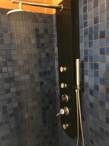 a shower in a bathroom with blue tiles at The White House by Casona Lo Aguirre - El Monte RM in Talagante