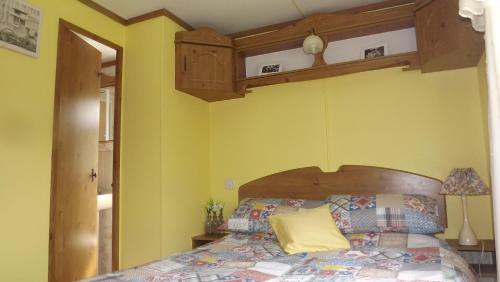 a bedroom with a bed with yellow walls at Hills View Accommadation in Borrisoleigh