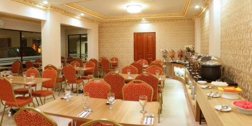 een restaurant met tafels en stoelen en een bar bij Hersya Front One Inn Surabaya in Surabaya