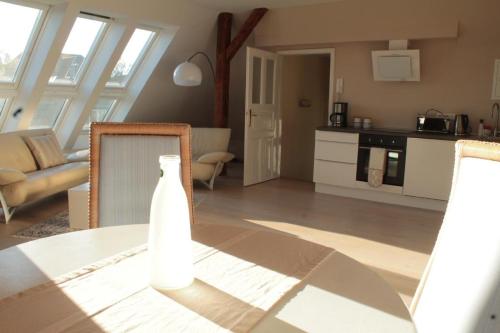 ein Wohnzimmer mit einem Tisch und einer Küche in der Unterkunft Düsternbrooker Villa in Kiel