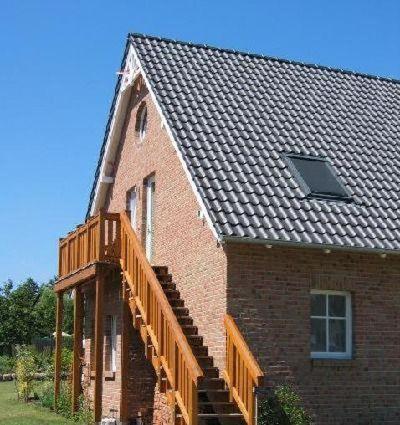 a brick house with a wooden staircase on it at Fewo-Kroeger in Lancken-Granitz