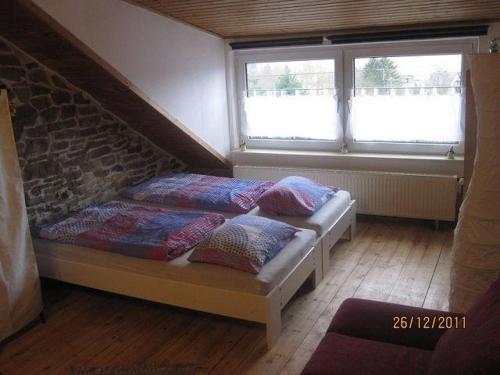 two beds in a room with two windows at Ferienwohnungen-Willrich-Ferienwohnung-2 in Blankenheim