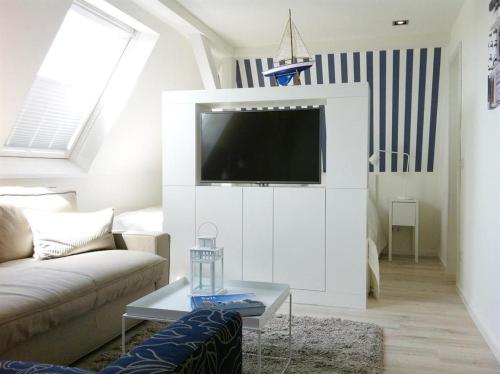 ヴェスターラントにあるHaus-LIV-Appartement-Meerのリビングルーム(ソファ、壁掛けテレビ付)