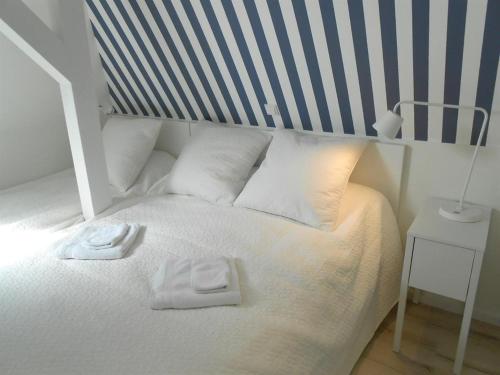 ヴェスターラントにあるHaus-LIV-Appartement-Meerの白いベッド(タオル2枚付)