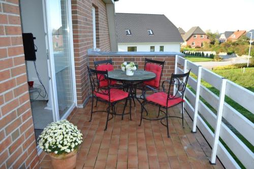 eine Terrasse mit einem Tisch und Stühlen auf dem Balkon in der Unterkunft Münstermann in Garding