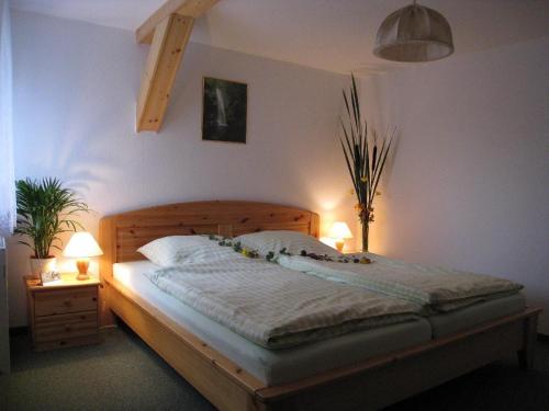 ヘルムスドルフにあるFerienwohnung-2のベッドルーム1室(木製ベッド1台、ランプ2つ付)