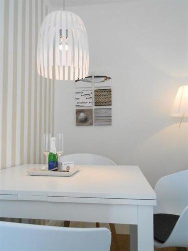 mesa de comedor blanca con lámpara de araña en Haus-LIV-Appartement-Sand en Westerland