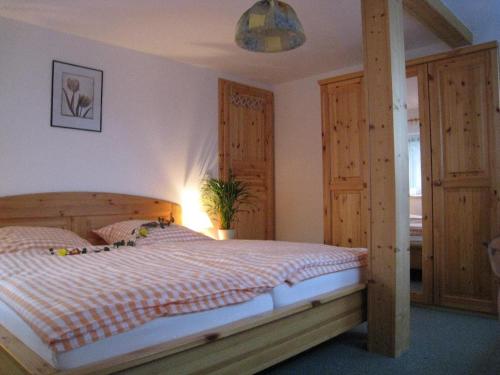 ein Schlafzimmer mit einem Bett mit einem Holzrahmen in der Unterkunft Ferienwohnung 1 in Hermsdorf