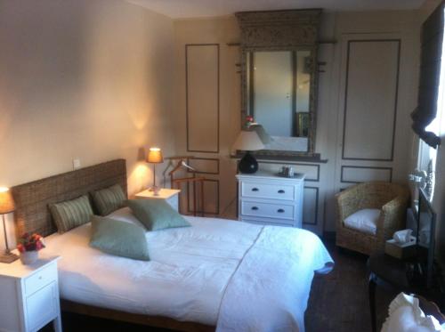a bedroom with a bed and a mirror and a chair at O Mylle Douceurs in Le Crotoy