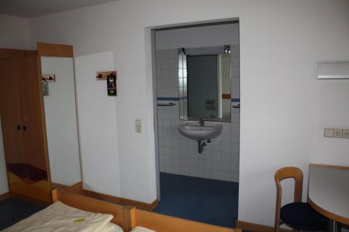 a bathroom with a sink and a mirror at Jugendherberge Stuttgart International in Stuttgart