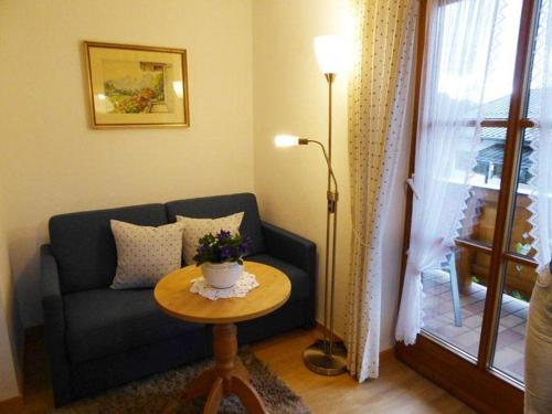 ein Wohnzimmer mit einem Sofa und einem Tisch in der Unterkunft Landhaus Haid Fewo Enzian in Schönau am Königssee