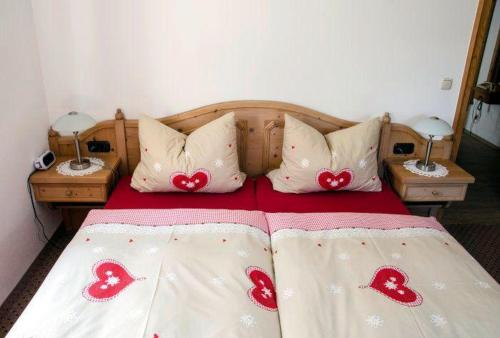a bed with red hearts on the sheets at Landhaus-Haid-Fewo-Edelweiss in Schönau am Königssee
