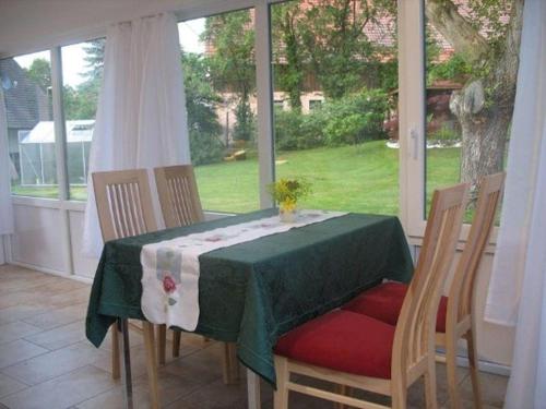 a dining room table with a green table cloth and chairs at Nussbaum in Überlingen