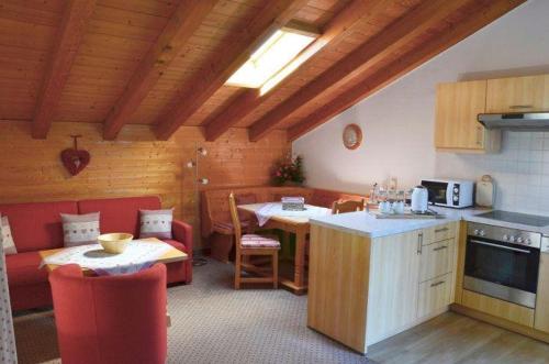 a kitchen and living room with a couch and a table at Landhaus-Haid-Fewo-Alpenrose in Schönau am Königssee