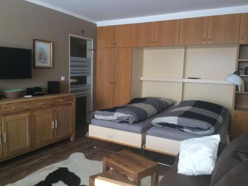 Schlafzimmer mit einem Bett und Schränken sowie einem TV in der Unterkunft Ferienwohnung Köhler in Altreichenau