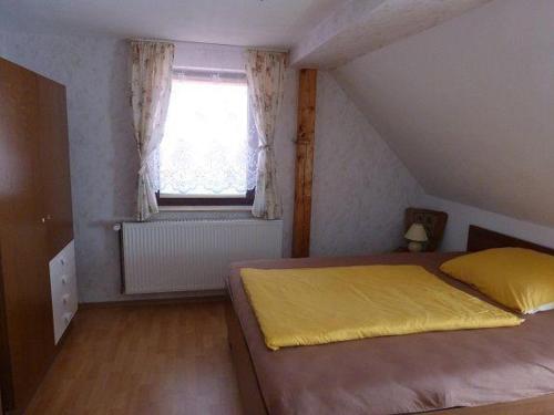 um quarto com uma cama amarela e uma janela em Ferienwohnung-Domsuehl em Domsühl