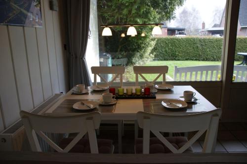 ブルハーフェにあるFerienhaus-Mellumringのテーブル、椅子2脚、テーブル、椅子