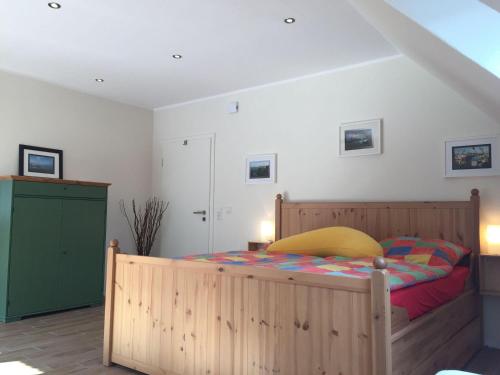 ディツムにあるHuus-Windroos-Wohnung-2のベッドルーム1室(木製ベッド1台、緑のキャビネット付)